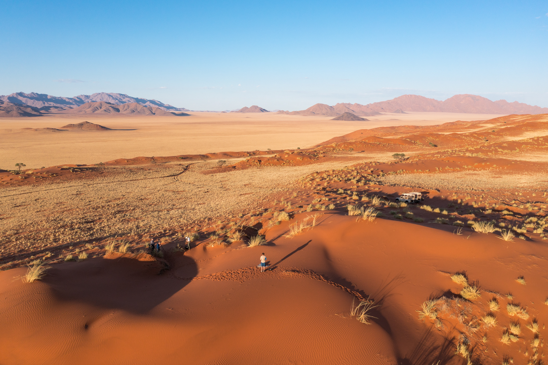 Drohenfoto von Teilnehmern in der Wüstenlandschaft Namibias.