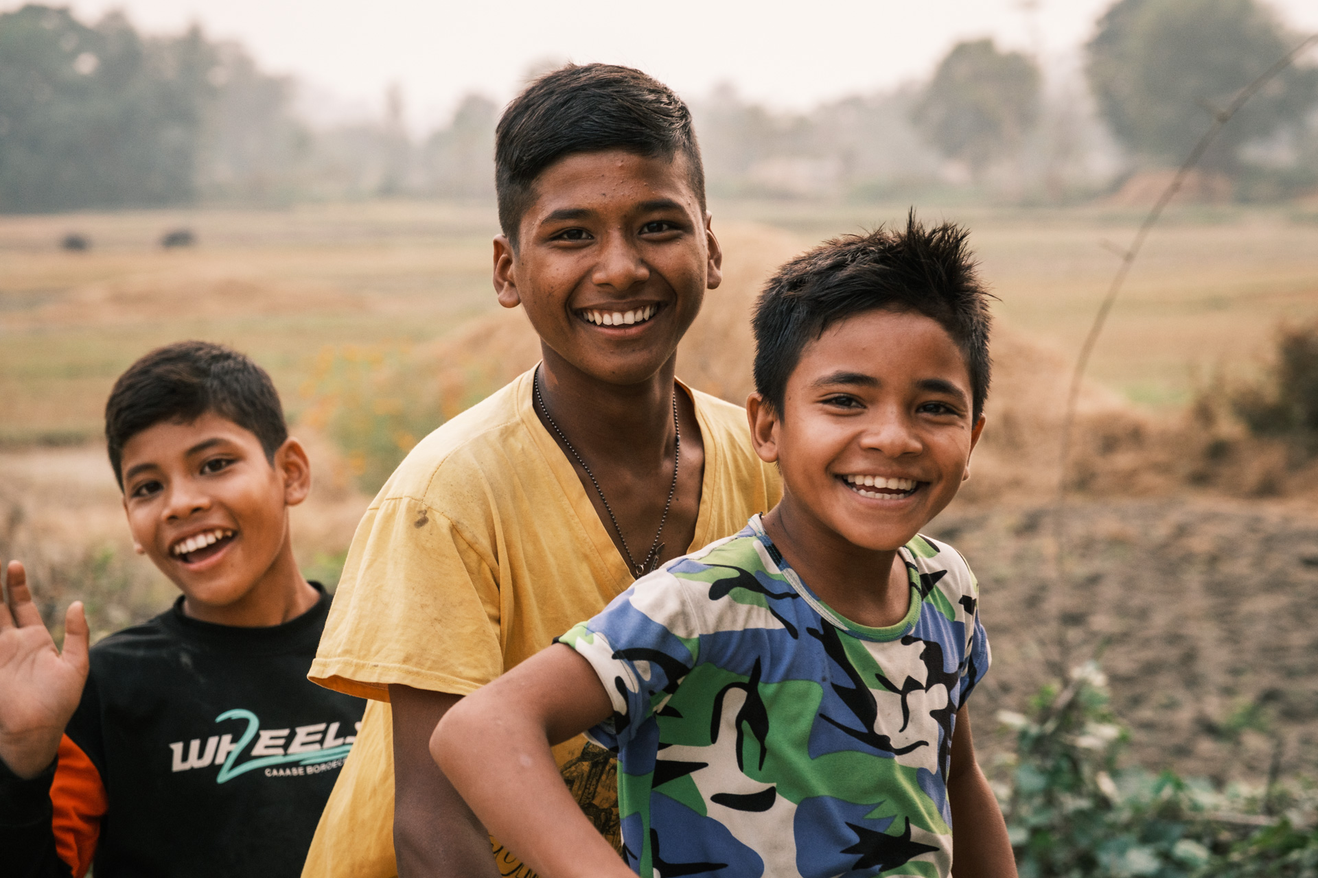 Drei Jungs auf dem Fahrrad in der Terai Region Nepals.