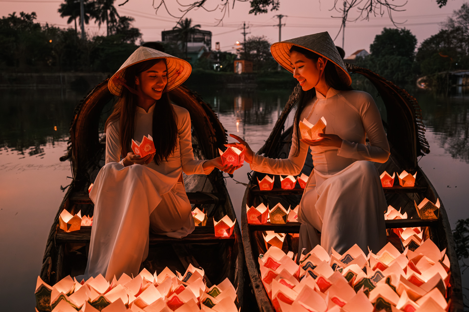 Models bei einer traditionellen Kerzenzeremonie auf Booten. 