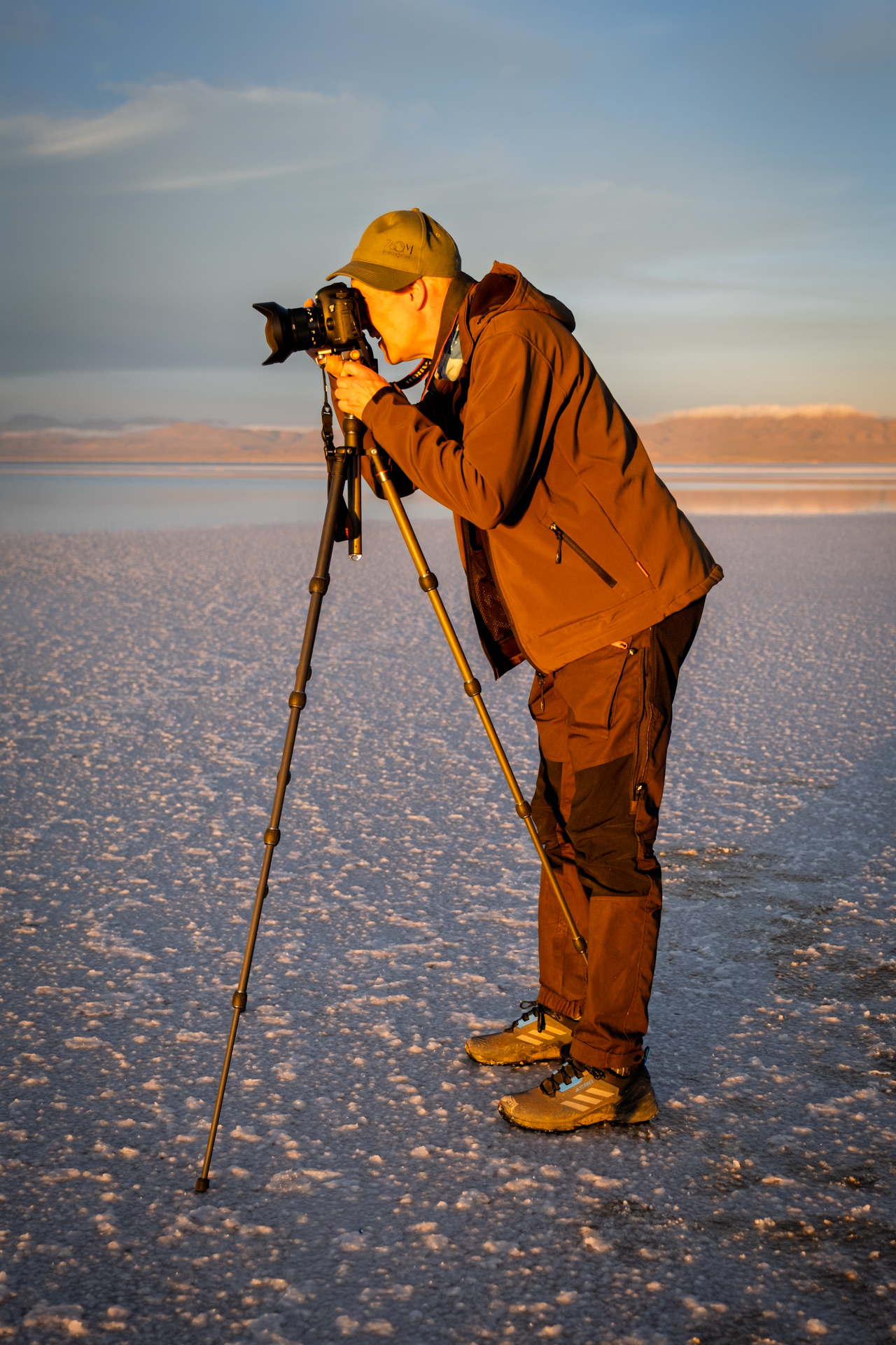 Fotograf bei der Arbeit auf einer Salzfläche im goldenen Abendlicht.