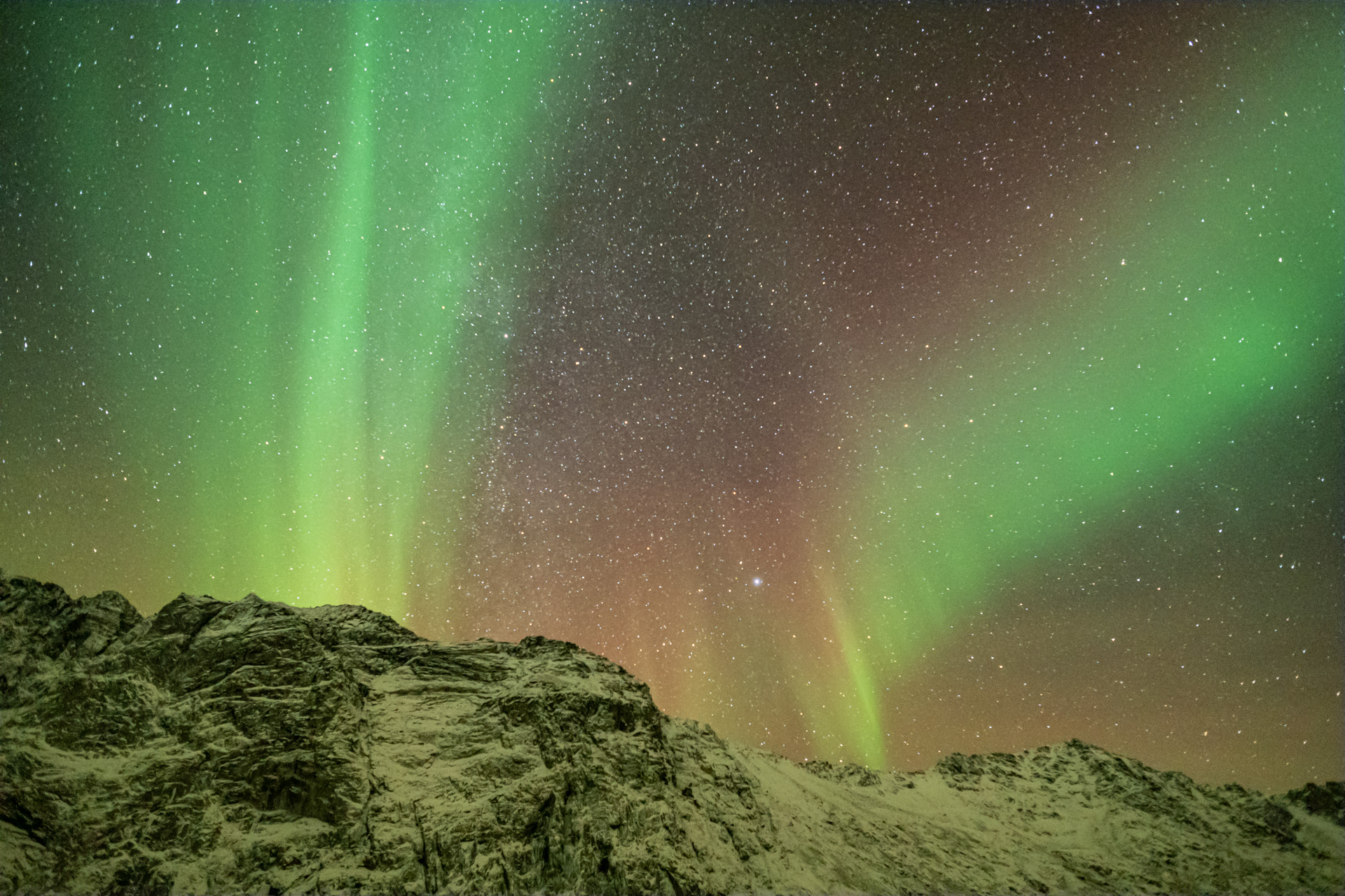 Starke Polarlichter über den Bergen Kvaløyas.