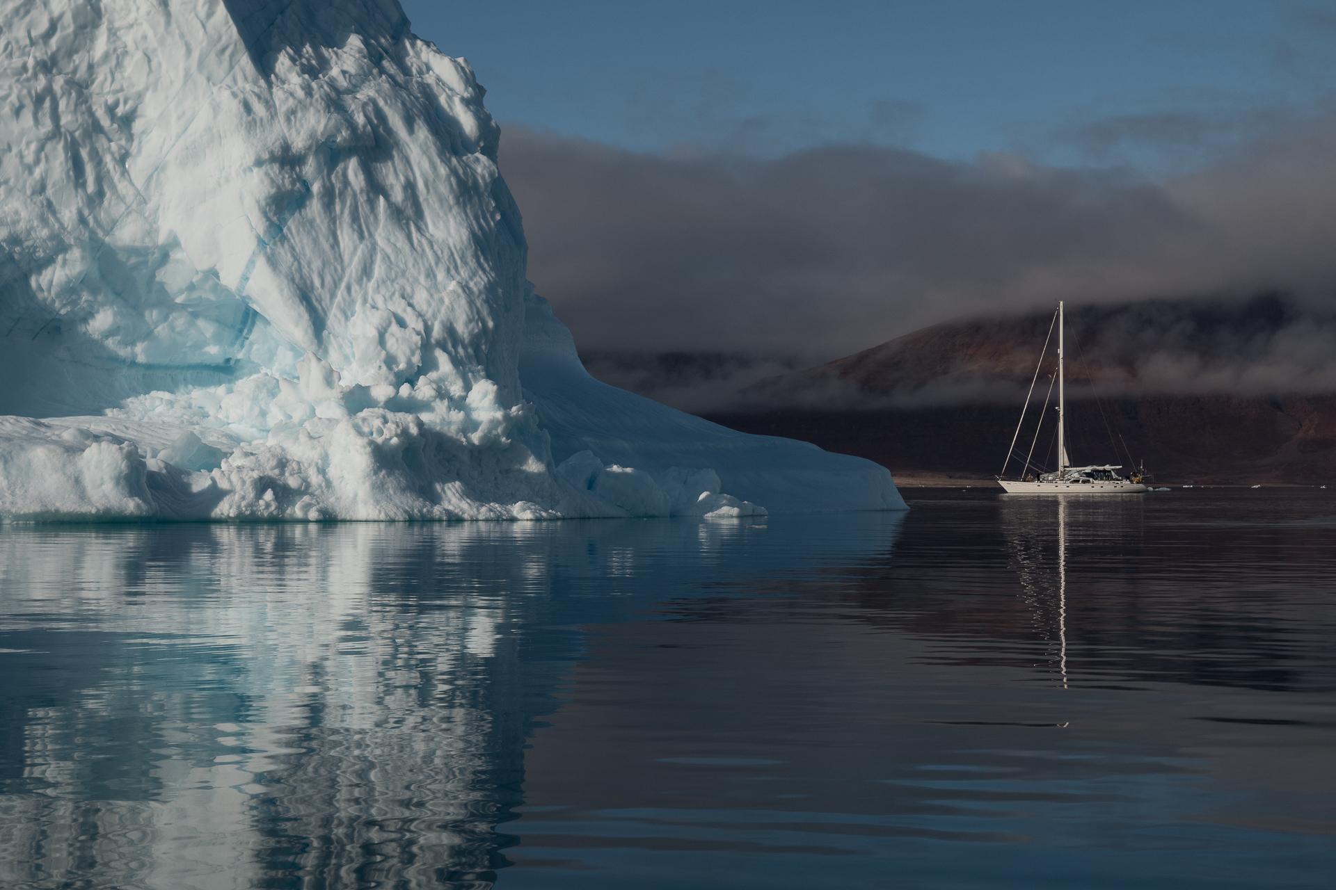 Segelschiff neben Eisberg