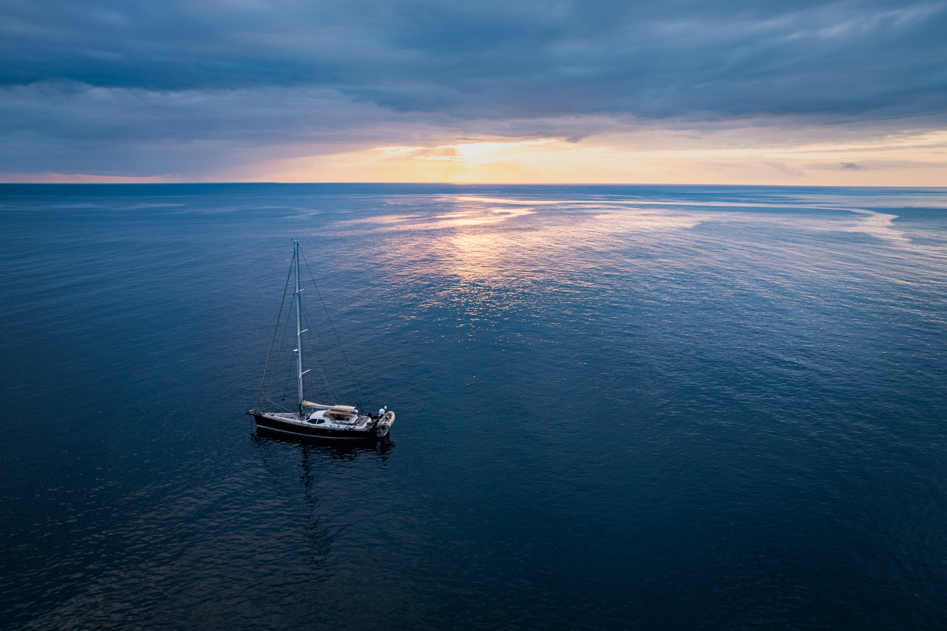 Eine Segelyacht vor dem Sonnenuntergang vor der Azoren Insel Flores.